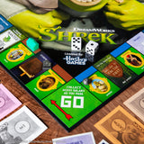 MONOPOLY: Shrek Edition Board Game, Buy, Sell & Trade, Iconic Fairy Tale Characters like Shrek, Donkey, Puss n Boots & More, Classic Family Game for Ages 8+, Officially Licensed DreamWorks Merchandise
